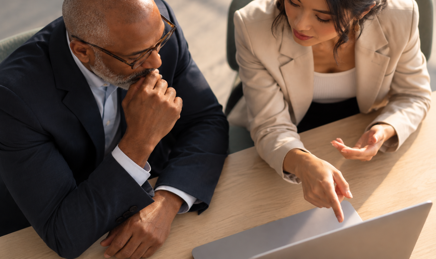 An attorney and paralegal discussing something on a laptop screen